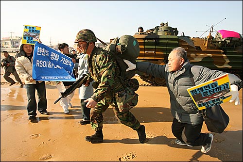 시위대가 상륙장갑차에서 내린 한국군을 붙잡고 훈련중단을 호소하고 있다. 